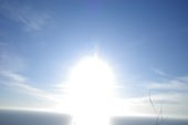 The sun flaring over a hillside