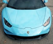 The front end of a light blue Lamborghini, close in