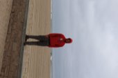 A figure in a red hoodie out on the sand